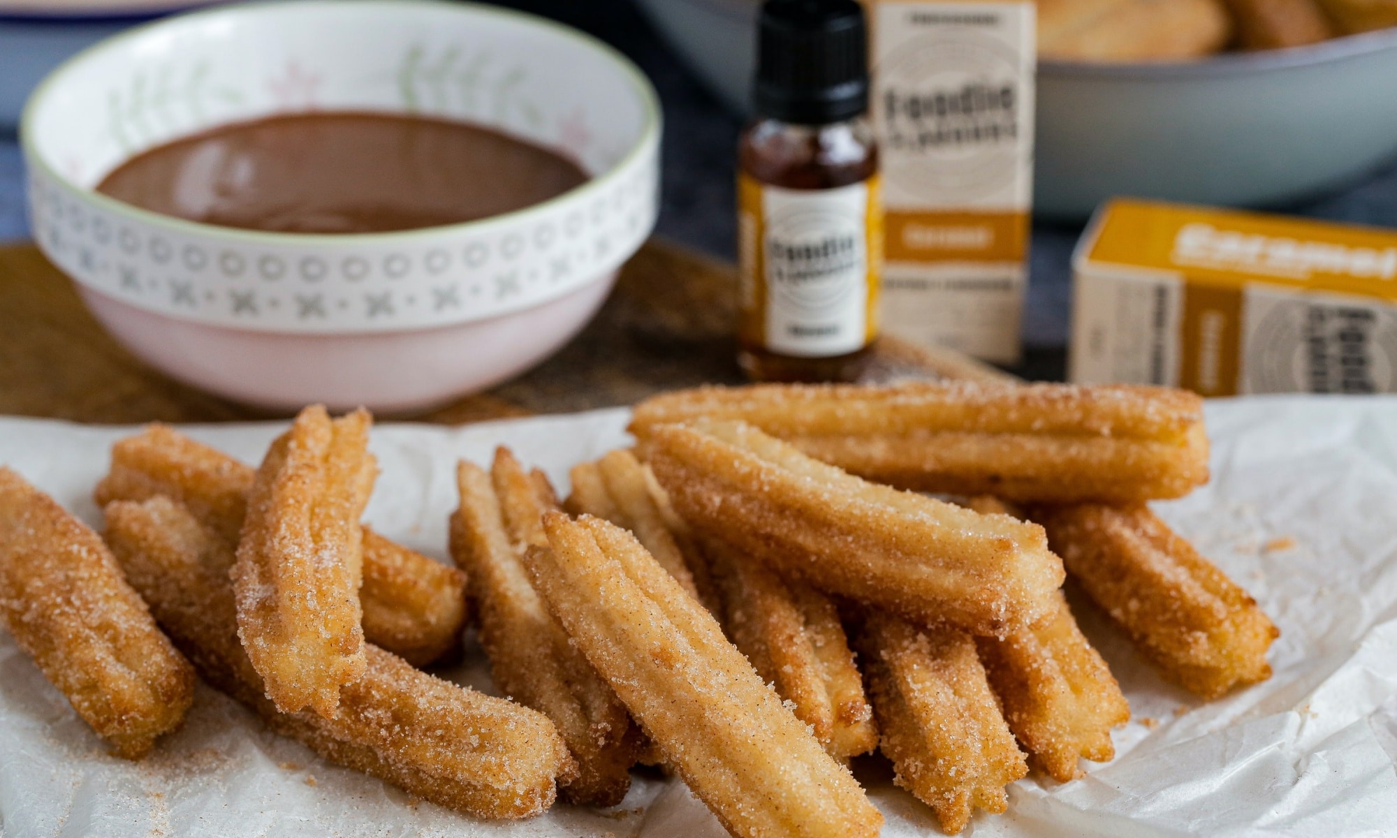 Churros on a paper towel and chocolate sauce on the side
